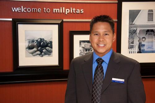 a man in a suit and tie posing for a picture at Hampton Inn Milpitas in Milpitas