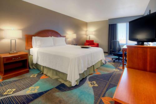 um quarto de hotel com uma cama e uma televisão de ecrã plano em Hampton Inn Milpitas em Milpitas