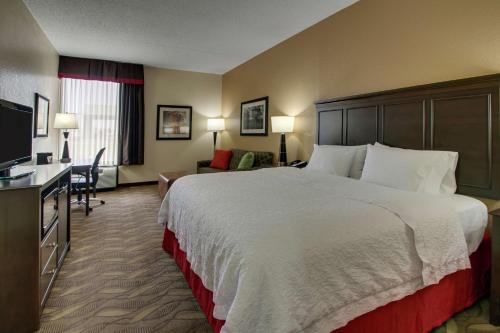 a hotel room with a large bed and a desk at Hampton Inn Lebanon in Lebanon