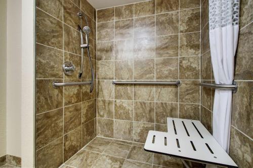 a bathroom with a shower with a bench in it at Hampton Inn Lebanon in Lebanon