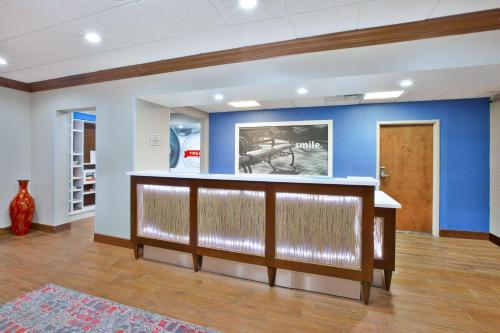 a lobby with a bar with a blue wall at Hampton Inn & Suites Springboro in Springboro