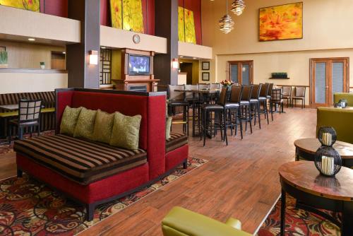 a restaurant with a couch and tables and chairs at Hampton Inn & Suites Springboro in Springboro