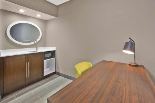 a room with a table and a mirror and a yellow chair at Hampton Inn & Suites Springboro in Springboro