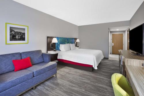 a hotel room with a bed and a couch at Hampton Inn & Suites Springboro in Springboro