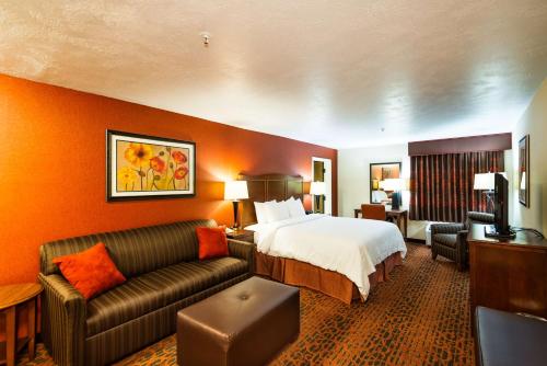 a hotel room with a bed and a couch at Hampton Inn St. George in St. George