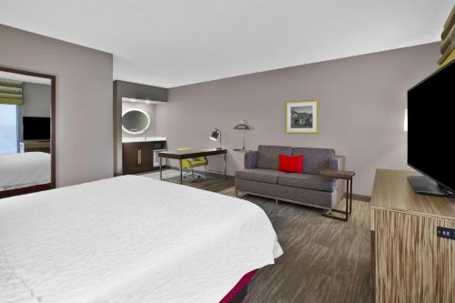a hotel room with a bed and a couch at Hampton Inn & Suites Springboro in Springboro