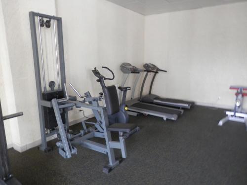 a gym with several tread machines in a room at Hotel POSHALE in Bryansk