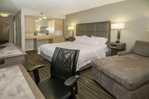 a hotel room with a bed and a chair at Hampton Inn Shreveport/Bossier City in Bossier City