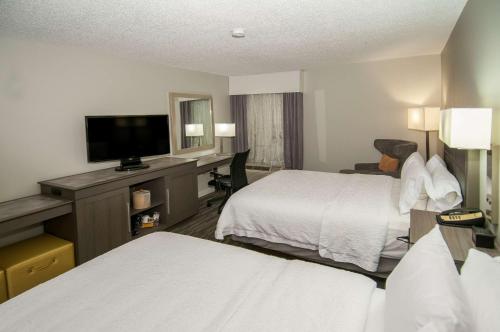a hotel room with two beds and a flat screen tv at Hampton Inn Shreveport/Bossier City in Bossier City