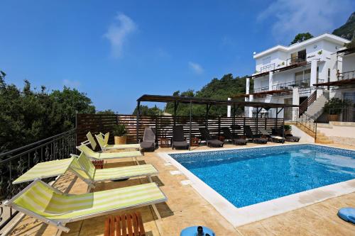 a swimming pool with lounge chairs and a building at Apartments Oktopus in Sutomore