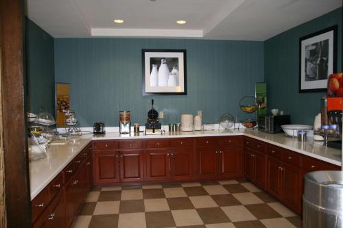 una cocina con armarios marrones y una pared azul en Hampton Inn Shreveport-Airport, en Shreveport
