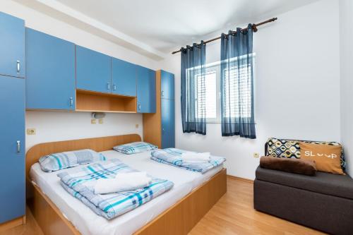 a bedroom with blue cabinets and a bed and a couch at Apartments Miranda in Lopar
