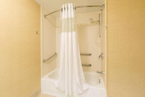 a shower with a white shower curtain in a bathroom at Hampton Inn Sidney in Sidney