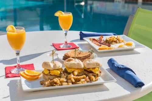 a table with two plates of food and two glasses of orange juice at Holiday Inn Melbourne-Viera Conference Ctr by IHG in Melbourne