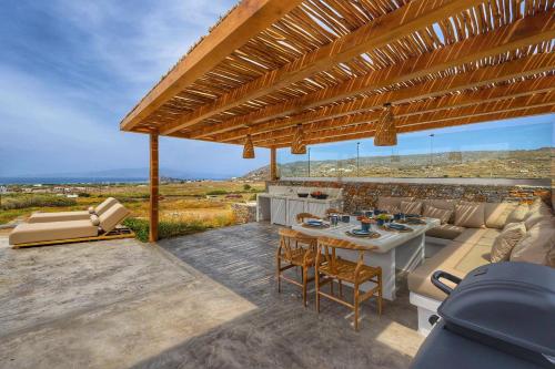 an outdoor patio with a table and chairs at The Nine Graces - Kastraki Villas with Private Swimming Pool in Kastraki Naxou
