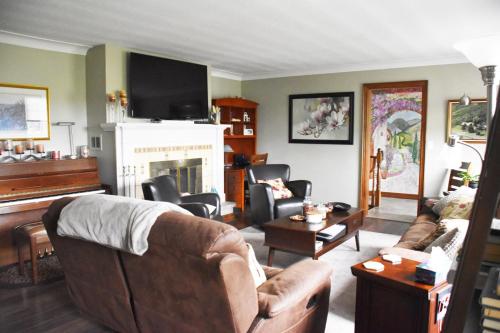 sala de estar con sofá y chimenea en As You Like It Bed and Breakfast, en Niagara on the Lake