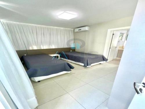 1 dormitorio con 2 camas y ventana. en Cobertura com piscina aquecida Mariscal 205 Palm, en Bombinhas