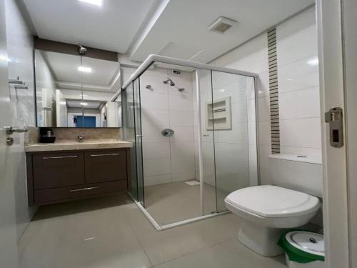 y baño con ducha de cristal y aseo. en Cobertura com piscina aquecida Mariscal 205 Palm, en Bombinhas