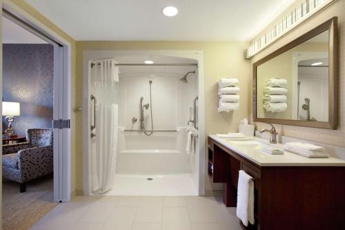 een badkamer met een bad, een douche en een wastafel bij Home2 Suites by Hilton West Valley City in West Valley City