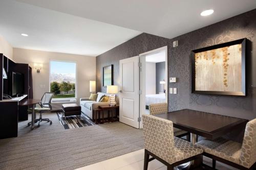 a living room with a dining room table and a bedroom at Home2 Suites by Hilton West Valley City in West Valley City
