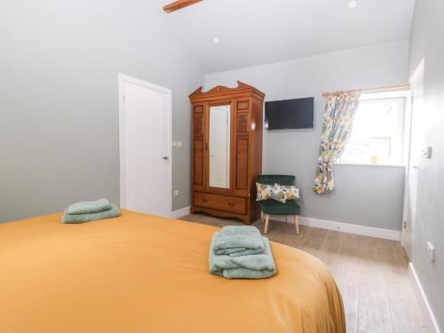 a bedroom with a bed with two towels on it at Y Beudy in Caernarfon