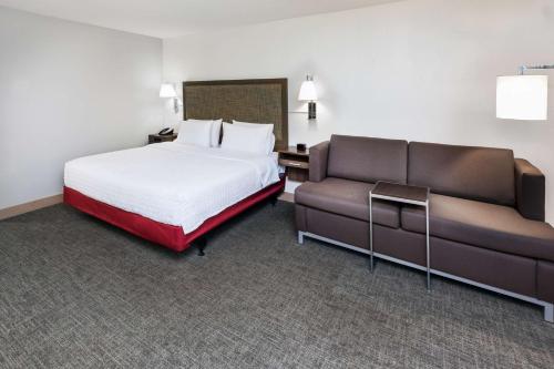 a hotel room with a bed and a couch at Hampton Inn Sulphur Lake Charles in Sulphur