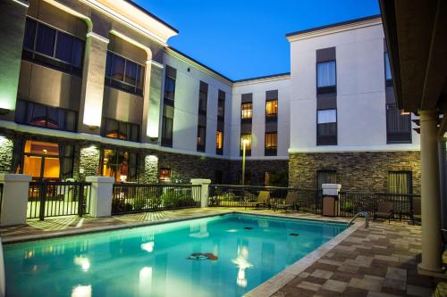 a swimming pool in front of a hotel at night at Hampton Inn & Suites Stillwater in Stillwater