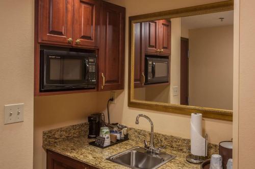 a kitchen counter with a sink and a mirror at Hampton Inn & Suites Stillwater in Stillwater