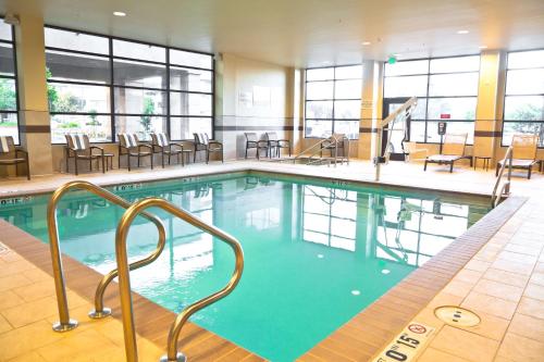 a pool in a hotel with chairs and tables at Hampton Inn & Suites Salinas in Salinas