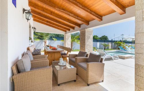 a patio with wicker furniture and a swimming pool at Beautiful Home In Pomer in Pomer