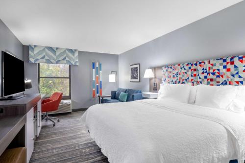 ein Hotelzimmer mit einem Bett und einem Flachbild-TV in der Unterkunft Hampton Inn Sanford in Sanford