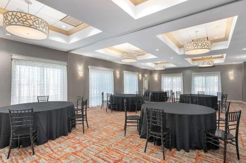 a banquet hall with black tables and chairs at Hampton Inn - Springfield in Springfield
