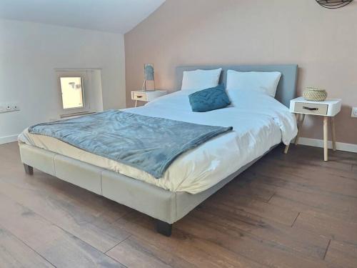 een slaapkamer met een groot bed en een blauwe deken bij Le Saint-Quentin in Longeville-lès-Metz