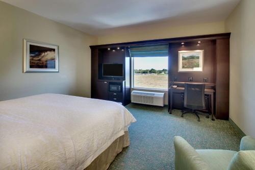 Vernon的住宿－弗農漢普頓酒店，配有一张床、一张书桌和一扇窗户的酒店客房