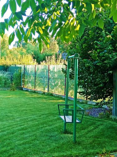 a green swing set in the middle of a yard at Private House with Garden in Mislea