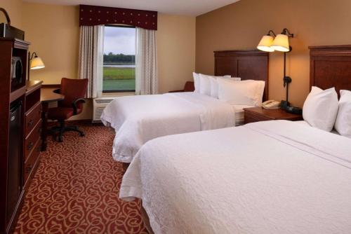 ein Hotelzimmer mit 2 Betten, einem Schreibtisch und einem Fenster in der Unterkunft Hampton Inn Lincoln in Lincoln