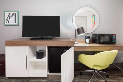 a desk with a tv and a yellow chair at Hampton Inn Ellenton/Bradenton in Ellenton