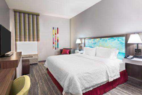 a hotel room with a bed and a flat screen tv at Hampton Inn Ellenton/Bradenton in Ellenton