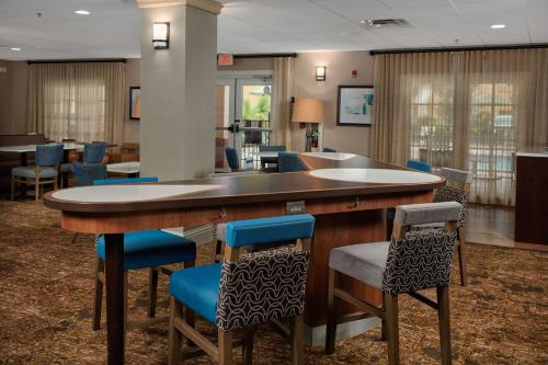 a lobby with a large bar with blue chairs at Homewood Suites by Hilton Sarasota in Sarasota