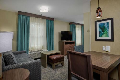 a hotel room with a dining table and a living room at Homewood Suites by Hilton Sarasota in Sarasota