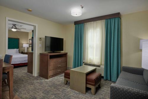 a hotel room with a room with a bed and a television at Homewood Suites by Hilton Sarasota in Sarasota