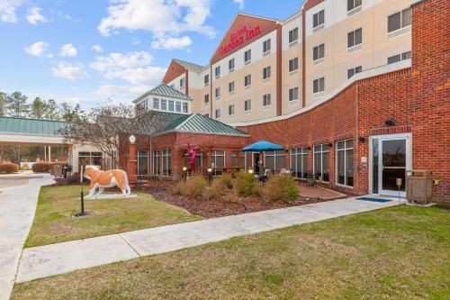 Un edificio con la statua di un cavallo davanti di Hilton Garden Inn Starkville a Starkville