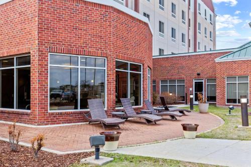 a brick building with a bunch of chairs in front of it at Hilton Garden Inn Starkville in Starkville