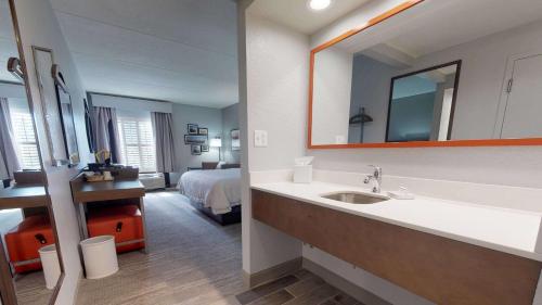 uma casa de banho com um lavatório e um quarto com uma cama em Hampton Inn St. Simons Island em Saint Simons Island