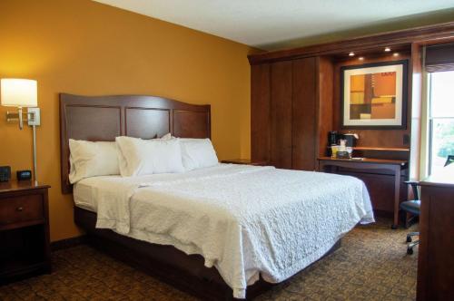 a bedroom with a large bed with a white bedspread at Hampton Inn St. Louis-Chesterfield in Chesterfield