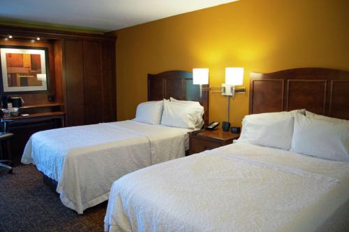 a hotel room with two beds with white sheets at Hampton Inn St. Louis-Chesterfield in Chesterfield
