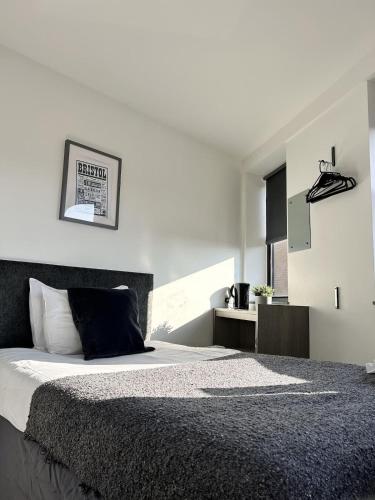 a bedroom with a large bed with a black headboard at Rooms Kingswood in Bristol