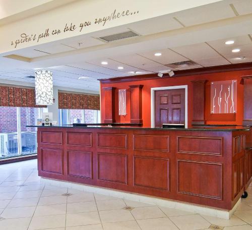 a bar in a lobby with orange walls at Hilton Garden Inn Starkville in Starkville