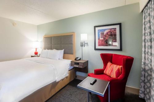 a hotel room with a bed and a red chair at Hampton Inn St Charles St Peters in St. Charles