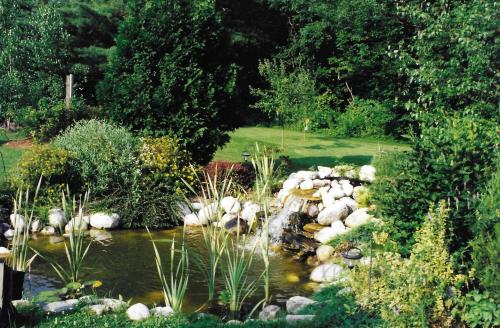 a pond with a waterfall in a garden at Arlington Inn & Spa in Arlington